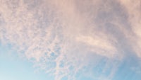 a person is flying a kite in a blue sky